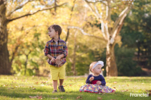 Two cute siblings playing with fall leaves in Schenley park